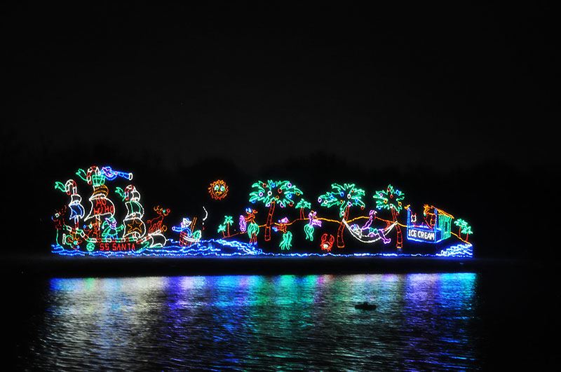 A Tropical-Themed Christmas Light Display Reflecting off the Pond Surface